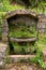 Moss covered water fountain in jungle forest.