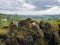 A mossy dry stone wall with a countryside landscape in the background