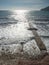 Mossy stony breakwater in calm water of sea