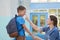 Mother accompanies the child to school. mom encourages student accompanying him to school. a caring mother looks tenderly at her