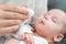 Mother administers oral drops to newborn, Concept of ensuring baby's health