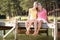 Mother and adult daughter sitting by lake