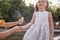 Mother applying insect repellent onto girl`s hand outdoors, closeup