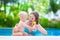 Mother applying sun screen on baby in swimming pool