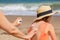 Mother applying sunburnt relief spray to her child at a beach