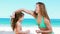 Mother applying sunscreen on her daughter