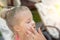 Mother applying sunscreen protection creme on cute little daughter nose face. Mom using sunblocking lotion to protect kid girl