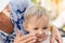 Mother applying sunscreen protection creme on cute little toddler boy face. Mom using sunblocking lotion to protect baby