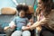 mother assists her youngster in fastening his seatbelt to keep him safe during a flight