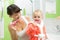 Mother with baby brushing teeth in bathroom