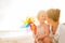 Mother and baby girl with windmill toy on beach