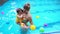 Mother and baby having fun in the swimming pool