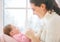 Mother and baby hugging near window