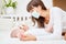 Mother and baby measuring fever with thermometer