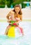 Mother and baby playing with beach ball in pool