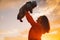 Mother and baby silhouettes at sunset on the sea beach