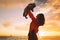 Mother and baby silhouettes at sunset on the sea beach