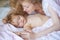 Mother and baby sleeping in the bed. Quiet sleep. Bedtime, childhood and family concept, close-up indoor portrait.