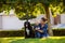 A mother with baby son and black dog in green neighborhood