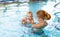 Mother and baby swim in pool