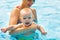 Mother and baby swim in pool