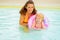 Mother and baby with swim ring swimming in pool