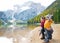 Mother and baby throwing stones on lake braies