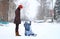 Mother and baby walk in winter with sledges