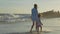 Mother with baby walking on sea coast with holding hands in slow motion.
