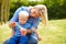 Mother Blowing Bubbles For Young Boy In Garden