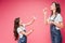 Mother blowing soap bubbles near joyful daughter isolated