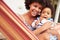 Mother bonding with young son sitting in a hammock, portrait