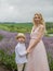Mother with boy holding hands have a rest in lavender field