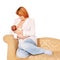 Mother breast-feeding newborn baby on the sofa