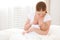 Mother breastfeeding newborn baby in white bed