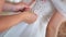 Mother bride tying white wedding dress. Unrecognizable persons. Slow motion.