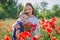 Mother brunette in white with son together on blossoming red poppies field