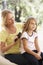 Mother Brushing Daughters Hair On Sofa At Home