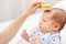 Mother brushing hair of newborn baby with soft brush