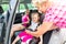 Mother buckling up on child in car