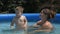 Mother caring and kissing baby son in the pool in slow motion