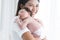 Mother carrying her newborn baby girl on shoulder at home. Cute 19 days Asian Australian infant baby sleeping in mom arms. Parent