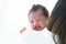 Mother carrying her newborn baby girl on shoulder at home. Cute 19 days Asian Australian infant baby smiling, laughing happy in