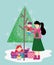 Mother carrying little boy and daughter with tree gifts merry christmas, happy new year