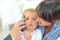 Mother carying baby talking on phone