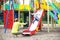 Mother catching son on playground slide