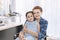 Mother Caucasian and kid smiling in hospital room.Waiting for doctor.