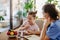 Mother checking girl's blood glucose level using a fingerstick glucose meter before meal.