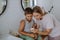 Mother checking her son's blood glucose level at home using a fingerstick glucose meter.