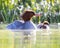 Mother and a chick common merganser floating on a river under a sunny day